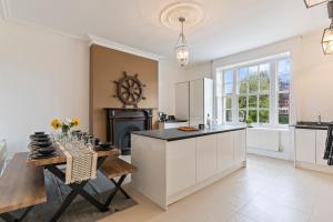 The Tewkesbury Country Escape في توكسبوري: مطبخ بدولاب بيضاء وطاولة ومدفأة
