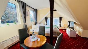 a hotel room with a bed and a table and chairs at "Sanddorn", Kur- und Ferienhotel, Direkte Strandlage, Fahrstuhl in Warnemünde