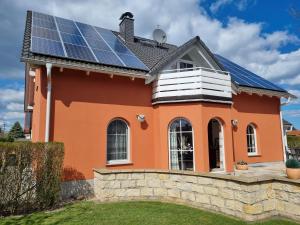 a house with solar panels on the roof at Ferienwohnung am Stadtrand von Dresden in Kesselsdorf