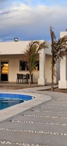 a house with a swimming pool next to a building at Camahuiroa Bungalows in Camahuiroa +4 photos