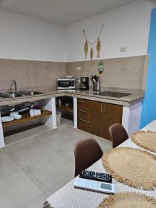 a kitchen with a sink and a counter with tables at Camahuiroa Bungalows in Camahuiroa