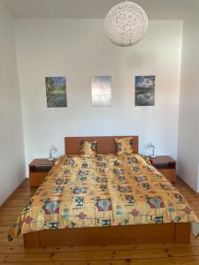 a bed with a quilt on it in a bedroom at Apartmány Obora v Podbezdězí in Doksy