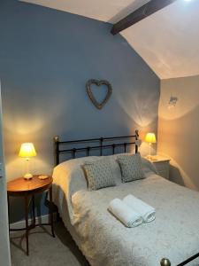a bedroom with a bed with a heart mirror on the wall at Miners Cottage in Bakewell