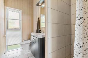 a bathroom with a toilet and a sink at 8424-Knebel-Rastestedet-46 in Knebel
