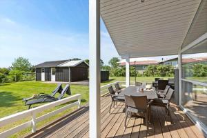 a patio with a table and chairs on a deck at 8424-Knebel-Rastestedet-46 in Knebel