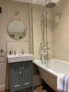 a bathroom with a tub and a sink and a shower at Miners Cottage in Bakewell +25 photos