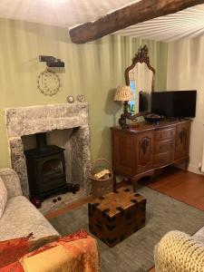 a living room with a fireplace and a television at Miners Cottage in Bakewell