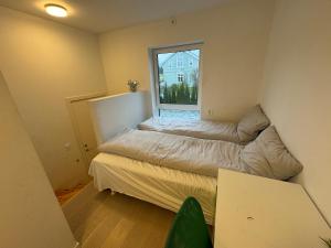 Un dormitorio pequeño con una cama y una ventana. en Lillestrøm home hybel uten soverom, en Lillestrøm