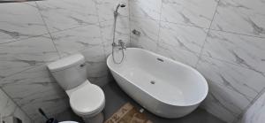 une salle de bain blanche avec toilettes et baignoire dans l'établissement Nkuche Apartments, à Lusaka 16 autres photos