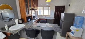 une cuisine avec un évier et un comptoir avec un évier dans l'établissement Nkuche Apartments, à Lusaka