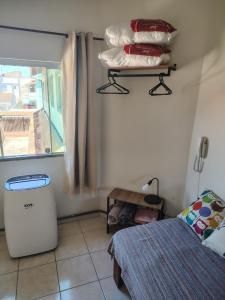 a bedroom with a bed and a window and a table at Espaço Acalanto in Rio das Ostras