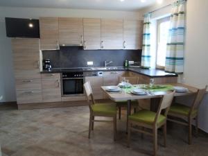 a kitchen with a wooden table with chairs and a tableablish at Ferienwohnung Lehenhof in Ried im Zillertal