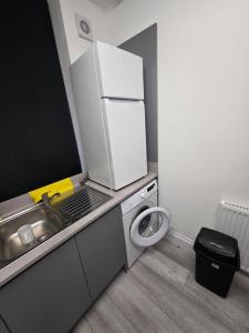a small kitchen with a sink and a refrigerator at Dress To Impress 3 in Amley