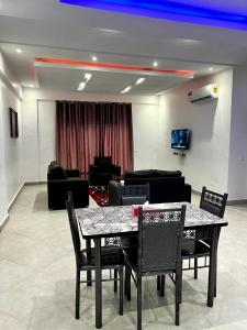 a dining table and chairs in a living room at Helios Towers in Accra +1 photo
