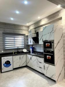 a kitchen with white marble counters and a sink at Helios Towers in Accra