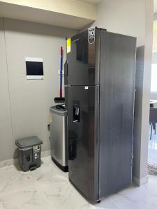 a large stainless steel refrigerator in a room at Moderno Apt en Reserva del Peñón en Girardot in Girardot