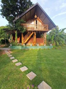 a house with a green yard with stepping stones at Lion Rock Haven Cabana in Sigiriya