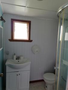 a bathroom with a sink and a toilet and a window at Casadelaisla-Rilan in Rilán