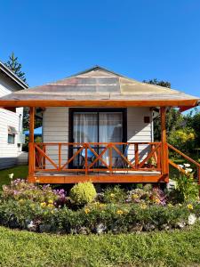 a house with a large wooden deck in the yard at Cabañas Casona Italiana in Lago Ranco +19 photos