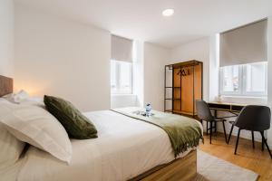 コインブラにあるMiCasa Studiosのベッドと机のある白い寝室