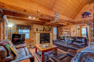 a living room with leather furniture and a fireplace at Bridgepoint Cabin in Banner Elk
