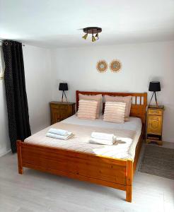 a bedroom with a wooden bed with two pillows at Belle île in Villers-le-Lac