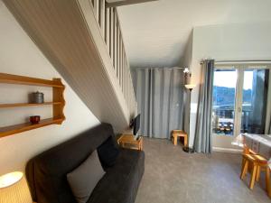 a living room with a couch and a window at Appartement 2P Mezzanine, 2 SDB, 6-7 couchages aux Saisies - FR-1-293-75 in Les Saisies
