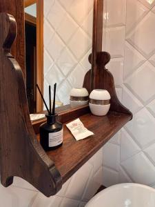 a bathroom with a wooden shelf next to a toilet at B&B Note di Verdi in Parma +25 photos