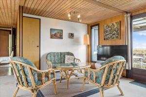 a living room with a table and chairs and a television at 30486-Odder-Kirkeager-5 in Odder