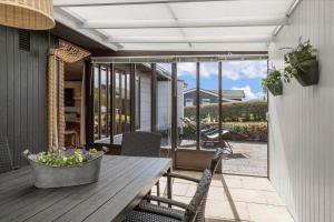 a patio with a wooden table and chairs on a porch at 30486-Odder-Kirkeager-5 in Odder