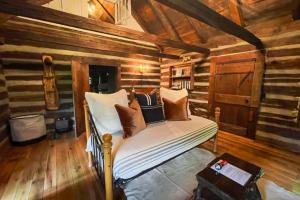 a bed in a room with wooden walls at Wagon Gap Trail: Lodge Lórien in Canton