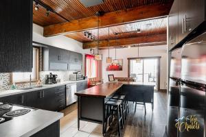 a kitchen with a large island in a kitchen with a table at Front LAKE Simon HOT TUB 6br 17p BEACH private in Lac-Simon