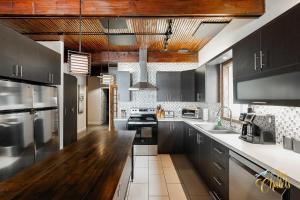 a kitchen with black cabinets and a wooden counter top at Front LAKE Simon HOT TUB 6br 17p BEACH private in Lac-Simon