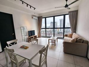 a living room with a table and a couch at Urban Suites Georgetown Penang - Affordable & Cozy Stay with High Floor-Sea & Penang Bridge View in George Town