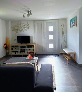 ヴィレ・ル・ラックにあるBelle îleのソファとテレビのあるリビングルーム