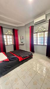 a bedroom with a bed and two windows with red curtains at D’sireh homestay in Sik