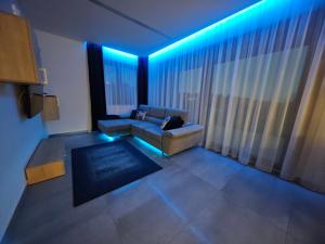 a living room with a couch and a large window at Gamma Apartmanok és Jakuzzi in Miskolctapolca +46 photos