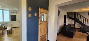 - un salon avec un mur bleu et une porte dans l'établissement Gites Le Saint Martin Le Convivial 6-8 people, à Blaslay