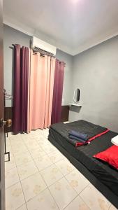 a bedroom with a bed with purple curtains at D’sireh homestay in Sik