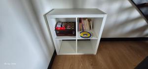 une petite étagère blanche avec des livres dessus dans l'établissement Gites Le Saint Martin Le Convivial 6-8 people, à Blaslay