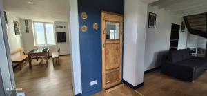 - un salon avec un mur bleu et une porte dans l'établissement Gites Le Saint Martin Le Convivial 6-8 people, à Blaslay 8 autres photos