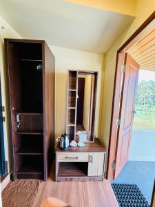 a room with an open door and a wooden cabinet at Almond Villa in Kappil
