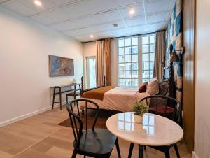 una habitación con una cama, una mesa y sillas en The Optimist Guesthouse | 4, en Camden