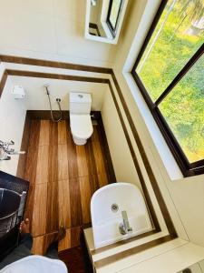 a small bathroom with a toilet and a window at Almond Villa in Kappil