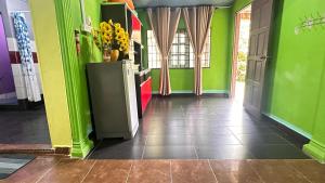 a room with green walls and a refrigerator with flowers on it at D’sireh homestay in Sik +4 photos