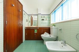 a bathroom with a toilet and a sink and a window at B28 - Stylish Typical House in Lagos +36 photos