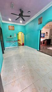 a room with a ceiling fan and a blue wall at D’sireh homestay in Sik