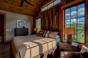 a bedroom with a bed in a room with windows at Banner View in Banner Elk
