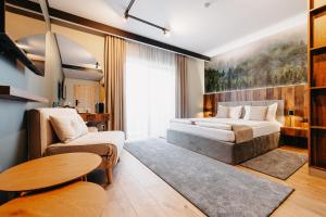 een slaapkamer met een bed, een bank en een tafel bij Barka in Borsec +38 foto's