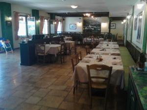 uma sala de jantar com mesas e cadeiras num restaurante em Ca' Del Bosco em Budòio